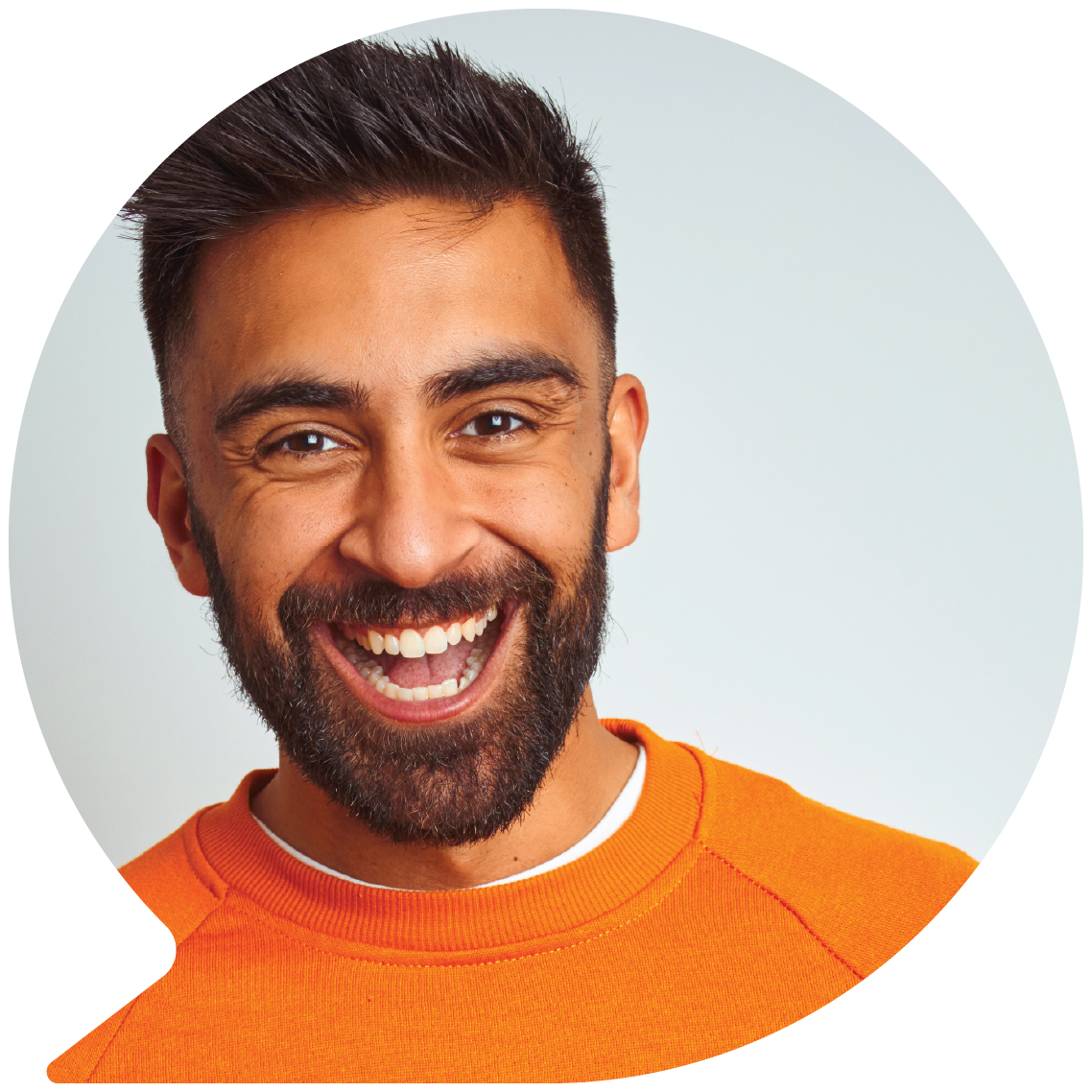 Image of a young man in an orange sweater smiling from inside a speech bubble